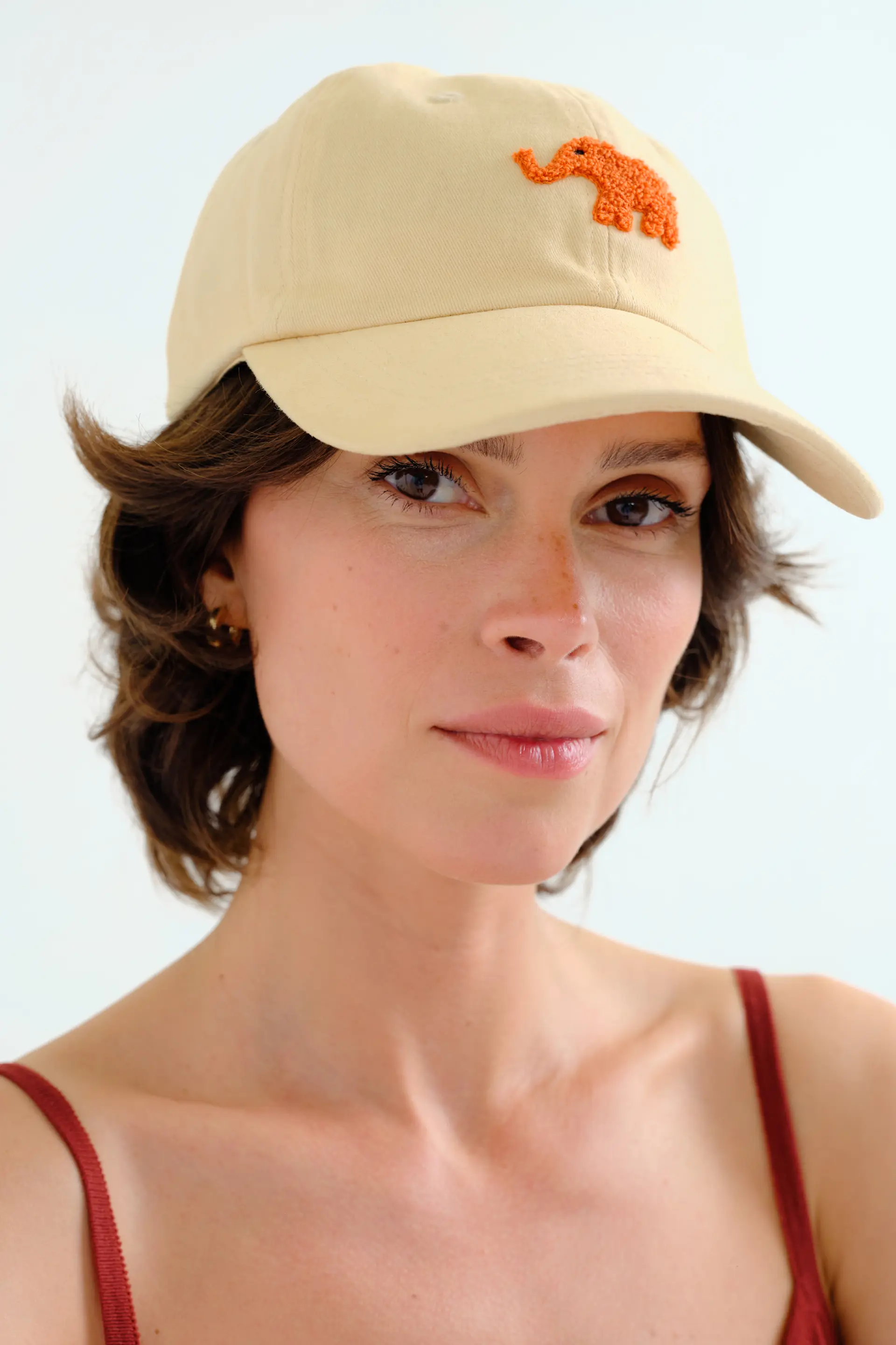 Gorra beige  con bordado de elefante rojo